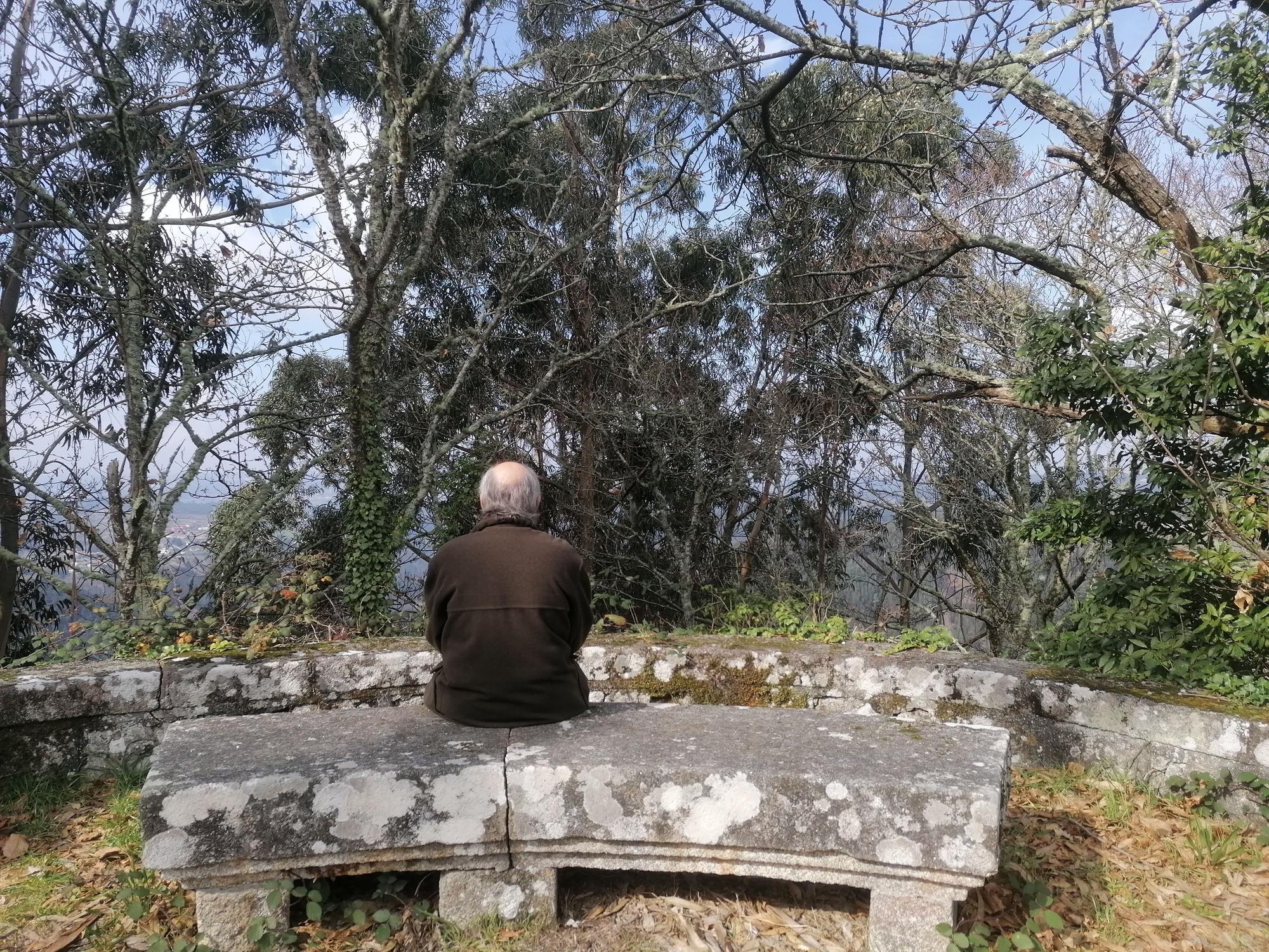 Bandín, sentado en uno de los bancos instalados en A Espenuca para disfrutar de las vistas, totalmente cubierta por eucaliptos