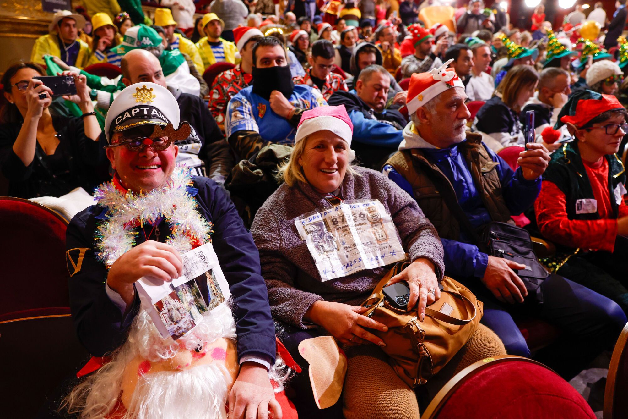 MADRID, 22/12/2024.- Varias personas lasisten al sorteo de la Lotería de Navidad este domingo en el Teatro Real, en Madrid. EFE/Javier Lizón