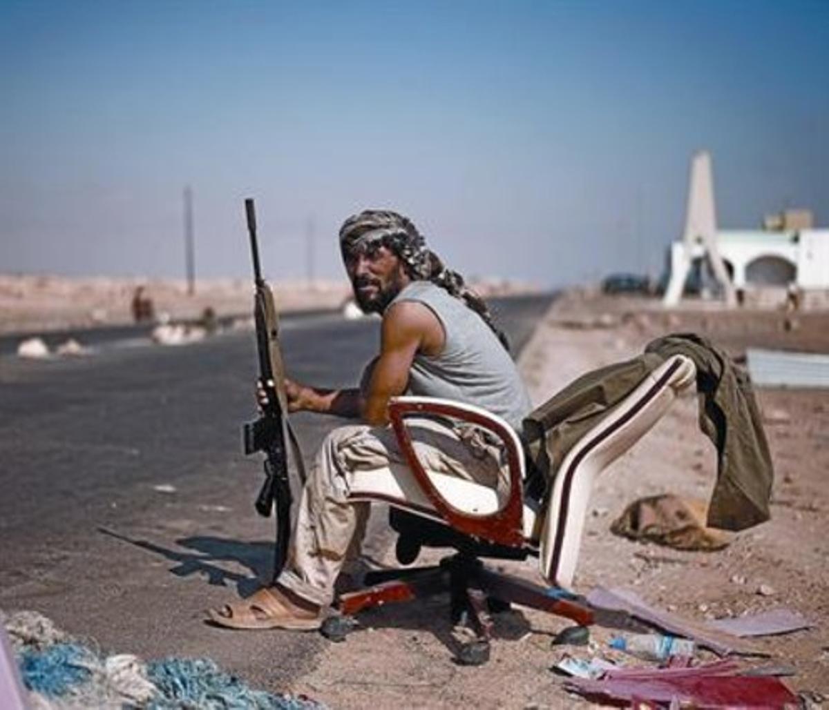 Un rebel libi, assegut en una cadira d’oficina, a prop d’un control a l’accés a Ras Lanouf.