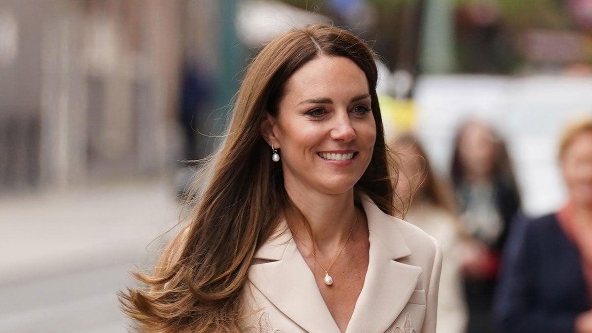 Primer plano de Kate Middleton con dos piezas con falda blanco roto