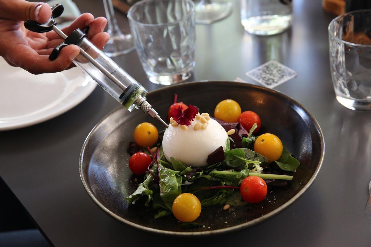 Burrata inyecta con pesto, con ensalada de tomates del Baix Llobregat.