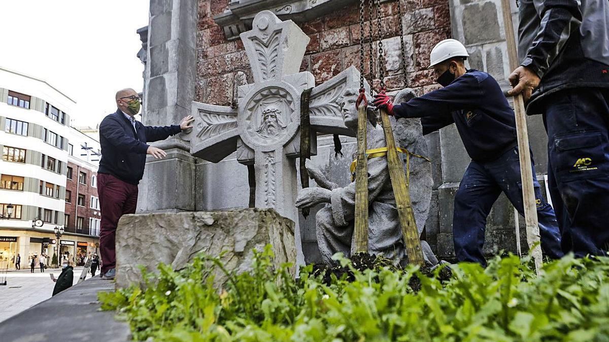 San Juan el Real coloca en sus jardines la cruz y el ángel restaurados | JULIÁN RUS