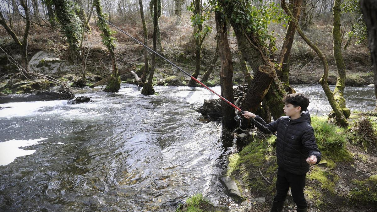Un neno pesca no río Asneiro