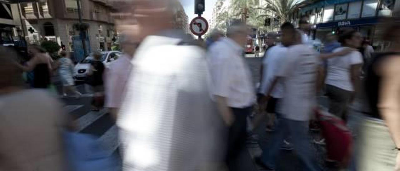 Un grupo de personas cruzan una calle en el centro de Alicante.