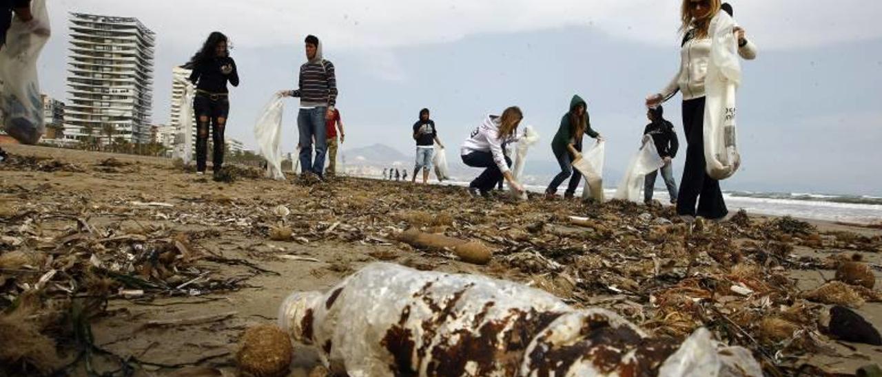 Un grupo de voluntarios limpia de residuos la arena de la playa de San Juan en una imagen de archivo