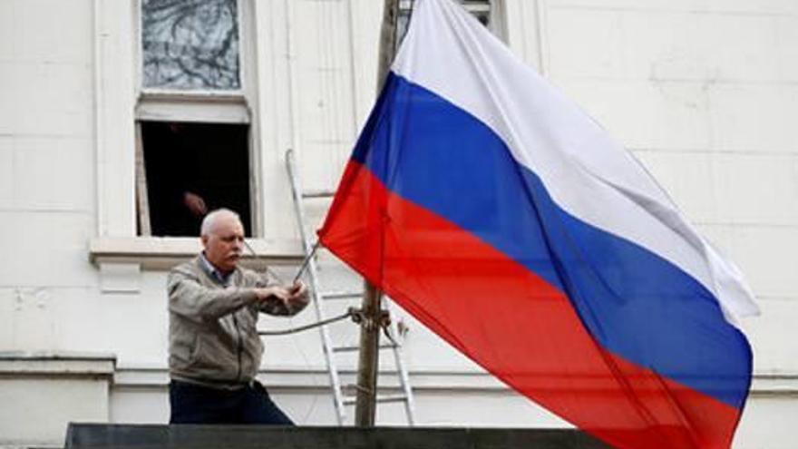 Un home retira la bandera de l&#039;ambaixada russa a Londres el dia 14 de març