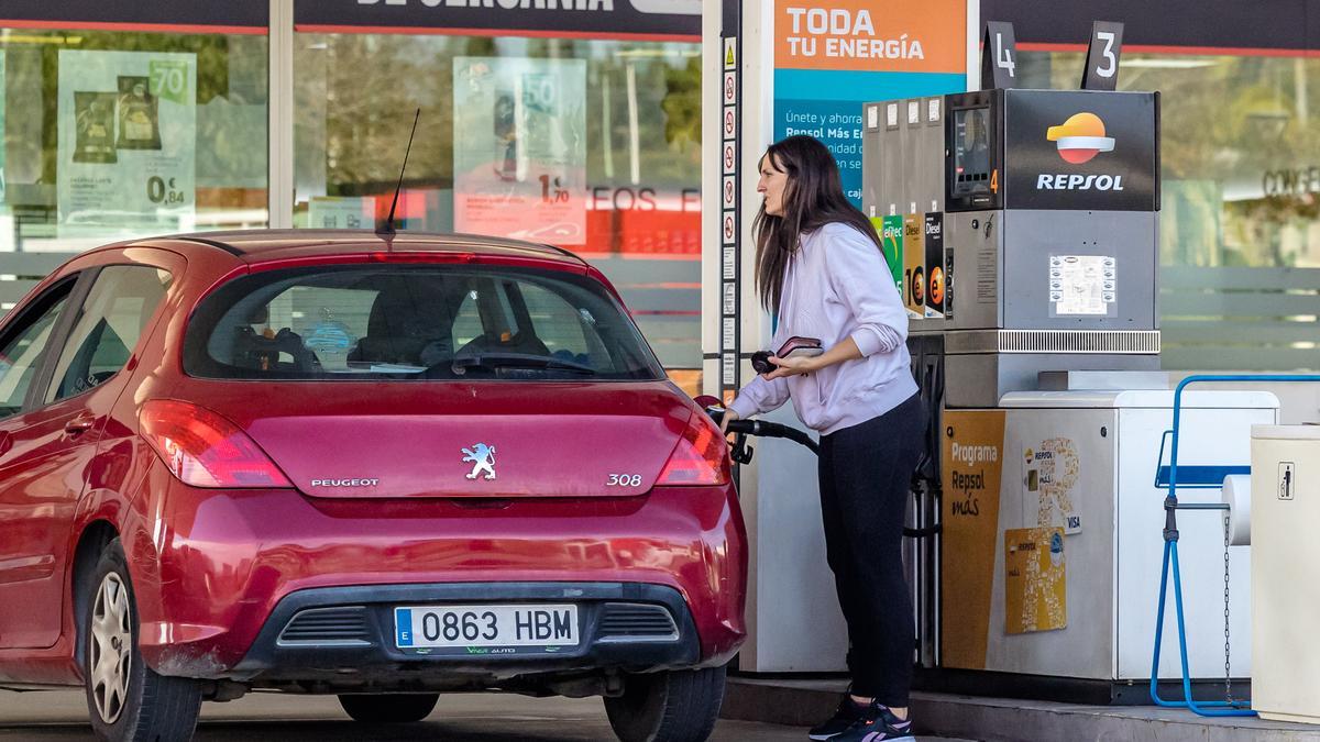 Una mujer llena el depósito en una gasolinera de Alicante.