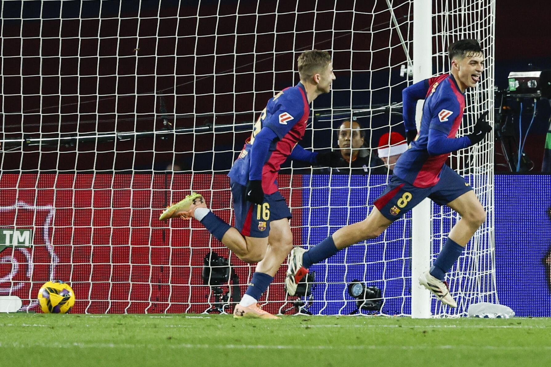 Barcelona's Pedri, right, celebrates after scoring the opening goal during the Spanish La Liga soccer match between Barcelona and Atletico Madrid at the Lluis Companys Olympic Stadium in Barcelona, Spain, Saturday, Dec. 21, 2024. (AP Photo/Joan Monfort). EDITORIAL USE ONLY/ONLY ITALY AND SPAIN