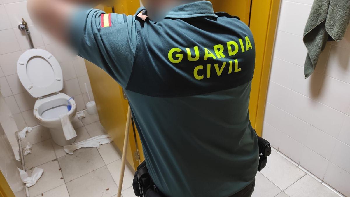 Un agente, fregona en mano, en los servicios del centro penitenciario.