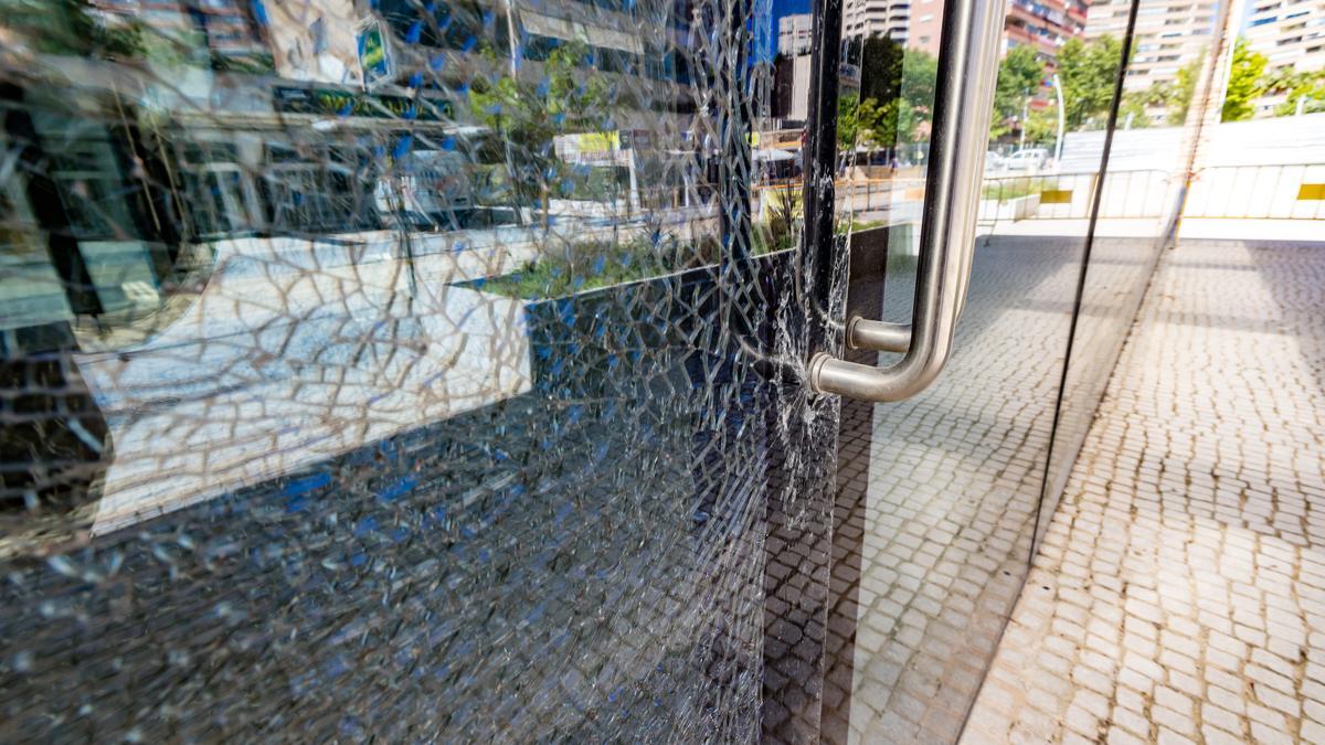 Una de las puertas de acceso con el cristal roto.