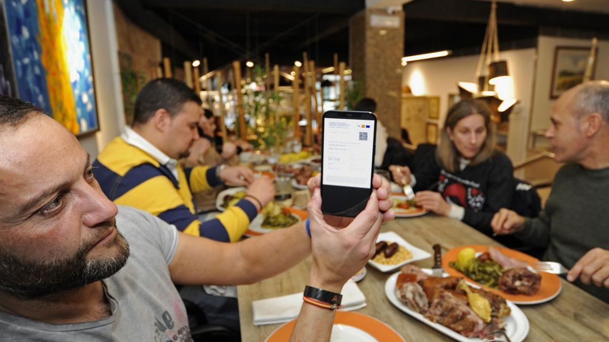 Un cliente muestra su pase COVID en un restaurante de Lalín. |   // BERNABÉ/JAVIER LALÍN