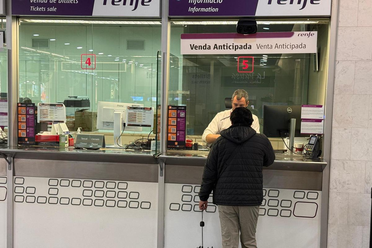 Un usuari compra un bitllet a les oficines de Renfe a Girona