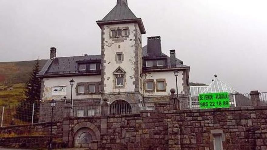 Exterior del parador de Pajares, donde se muestra el cartel de «se vende» y un número de teléfono.