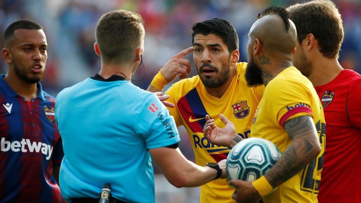 Los jugadores del Barça rodean al árbitro en el partido ante el Levante.