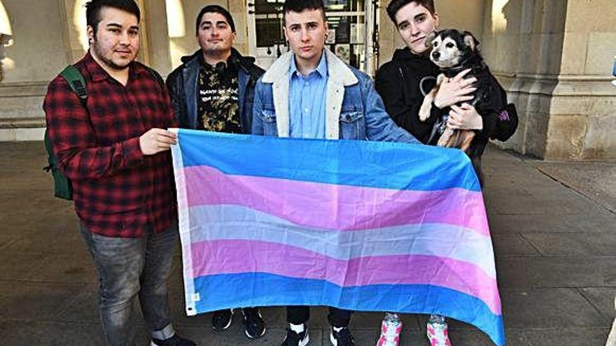 Marco André Comesaña, Patrick Dopico, André López y Tom Martínez, con la bandera del colectivo &#039;trans&#039;, en los soportales del Palacio Municipal.