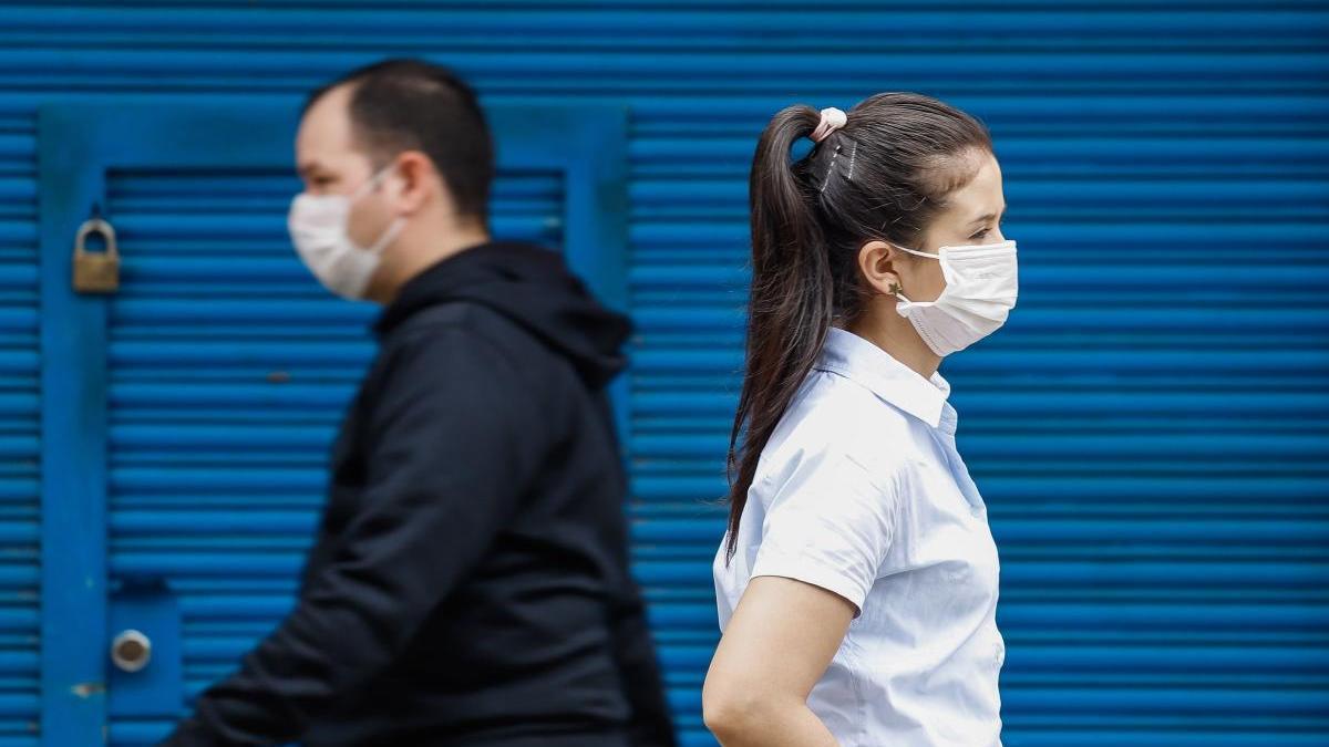 Dos personas caminan con mascarillas en Asunción.