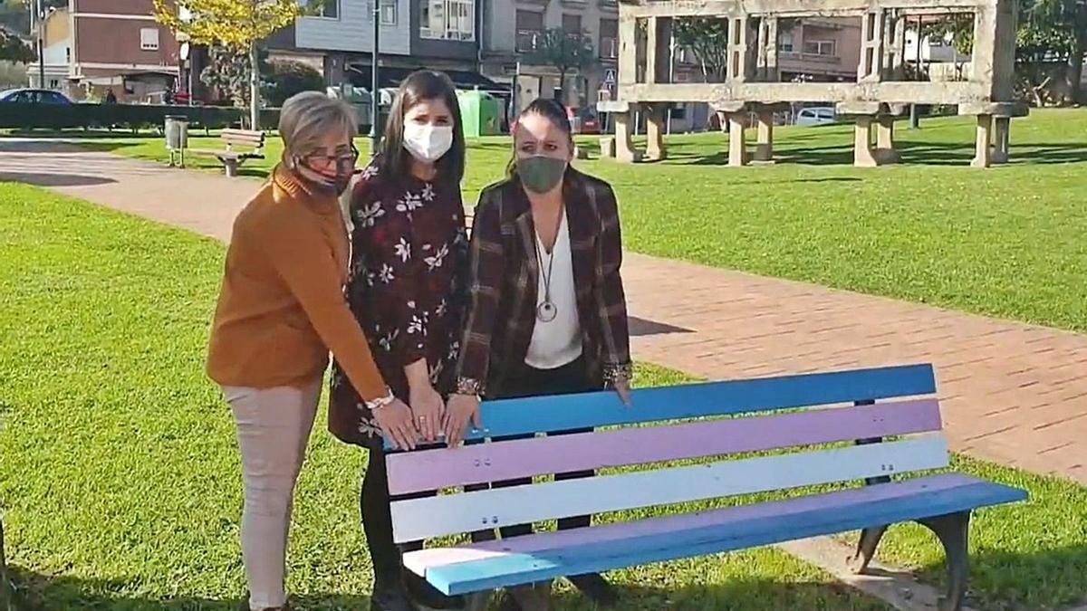 Coral Ríos, Leticia Santos y Marta Freire junto al banco con la placa que reconoce la lucha LGTBI.   | // FDV