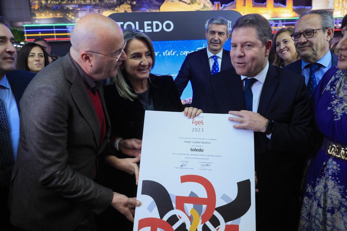 MADRID, 18/01/2023.- El presidente de Castilla la Mancha, Emiliano García-Page (d), recibe el premio a la mejor ciudad túristica que la Asociación de Periodistas de Turismo le ha concedido a Toledo, este miércoles, durante la inauguración de la feria internacional de turismo Fitur, que arranca su 43 edición con 8.500 empresas participantes, 131 países (entre ellos Ucrania) y 755 expositores, y confía en que este año marque el de la plena recuperación del sector tras la pandemia. EFE/Fernando Alvarado