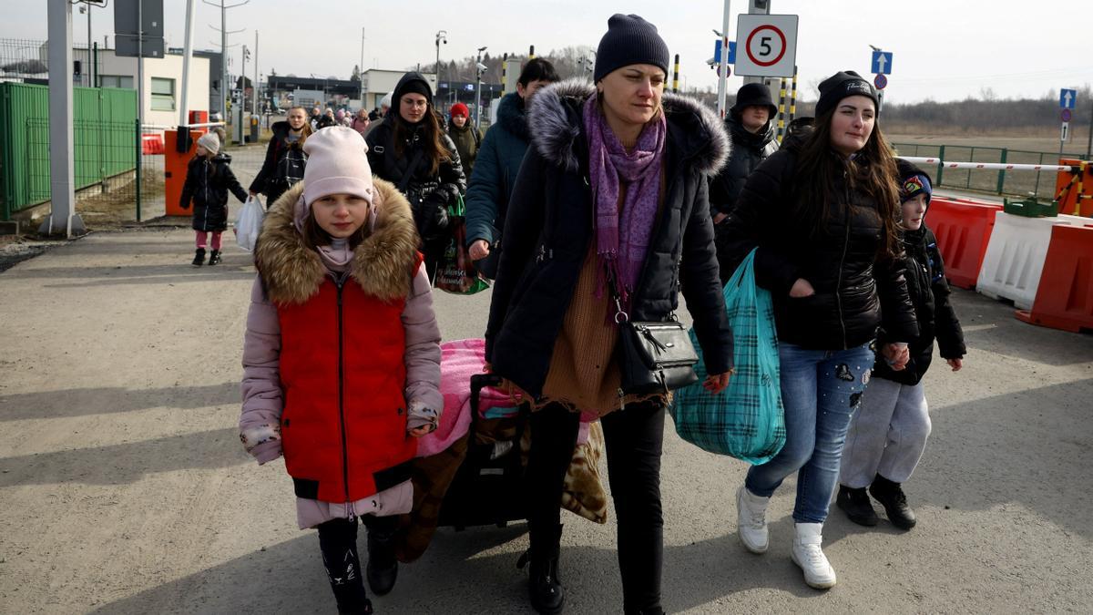 Refugiados ucranianos cruzan la frontera entre su país y Polonia por la población de Medyka.