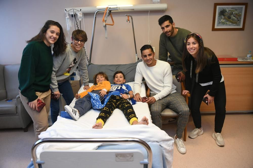 Dos futbolistas del primer equipo -David Simón y Eneko Bóveda-, junto a tres jugadoras del Deportivo Abanca -Cris, Laura y Miriam- visitam a los niños hospitalizados.