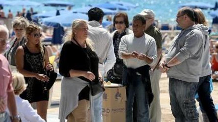 Un grupo de gente alrededor de una de las prácticas del «trile» en Benidorm.