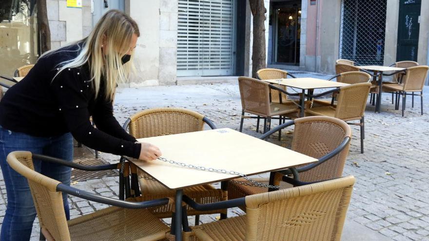 Una treballadora d&#039;un bar de Girona, tancant la terrassa a primera hora de la tarda