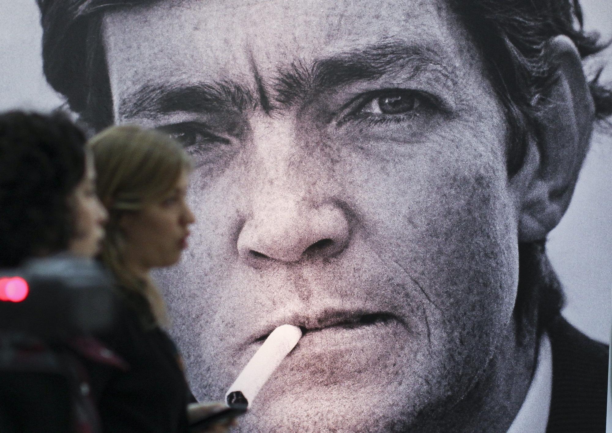 Dos mujeres pasean ante una imagen de Julio Cortázar, en Buenos Aires.