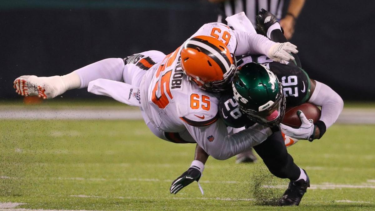 Larry Ogunjobi #65 de los Cleveland Browns placa a Le'Veon Bell #26 de los New York Jets en el MetLife Stadiumen East Rutherford, New Jersey.