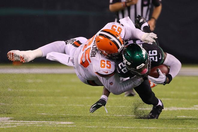 Larry Ogunjobi #65 de los Cleveland Browns placa a LeVeon Bell #26 de los New York Jets en el MetLife Stadiumen East Rutherford, New Jersey.