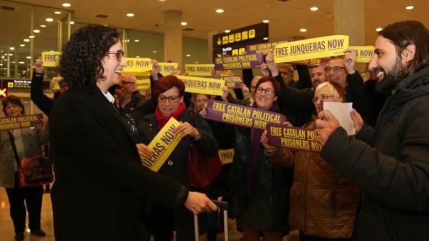 Diverses persones reben Rovira al Prat amb pancartes de suport