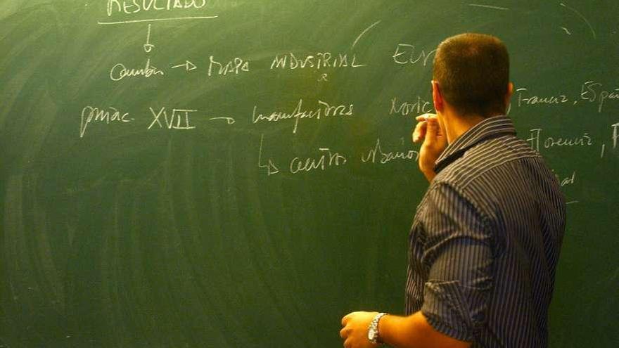 Un profesor escribe en la pizarra del aula. / fran martínez