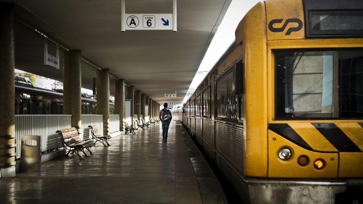 Un hombre pasa frente a un tren en Lisboa.