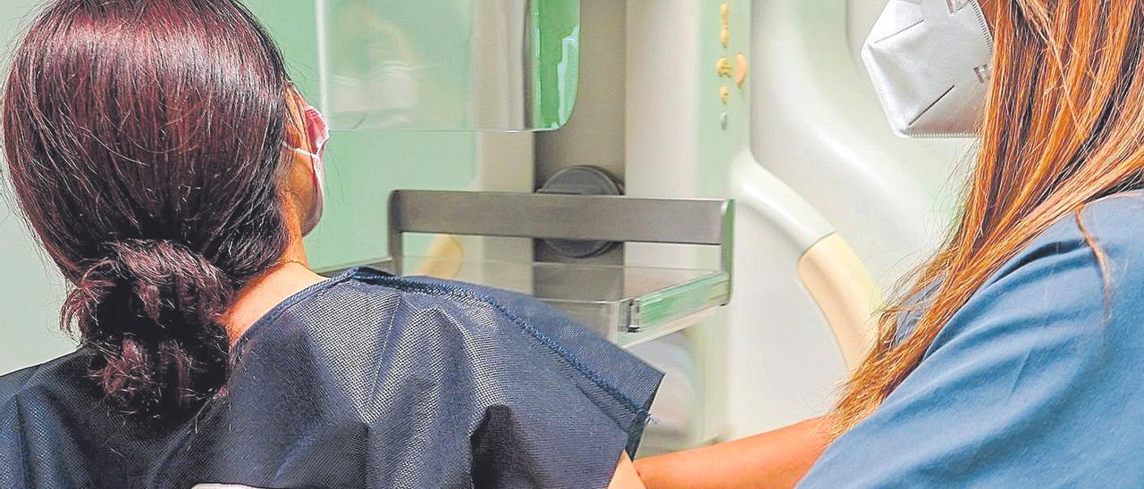Una enfermera ayuda a una paciente a someterse a una mamografía.