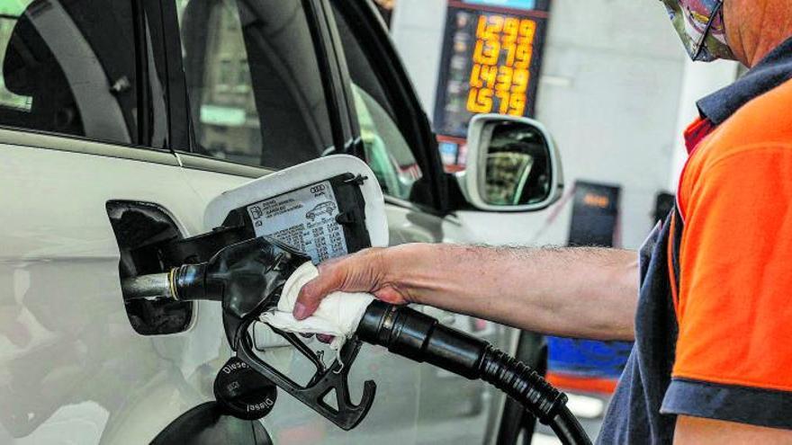 Un trabajador de una estación de servicio llena el depósito de un coche. |  Emilio Fraile