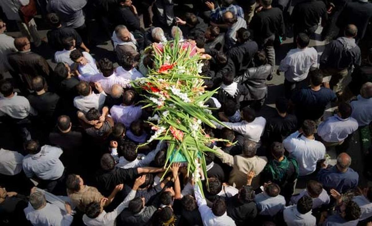 La gent toca un taüt durant el funeral per les restes trobades recentment d’un soldat desconegut de la guerra del 1980-88 entre l’Iran i l’Iraq a Teheran.