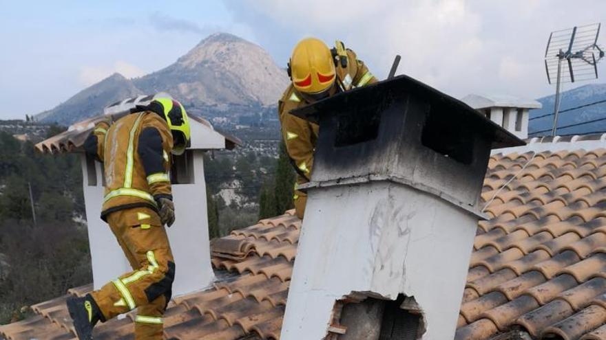 Los bomberos junto a la chimenea en el tejado