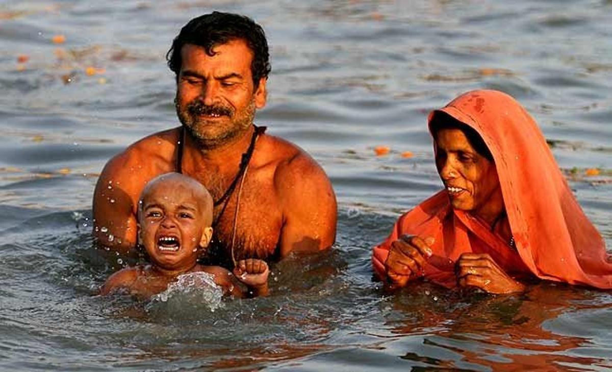 Un nen plora quan els seus pares el banyen al riu Ganges, per la celebració del Basant Panchmi a Allahabad (Índia). Milers de pelegrins hindús prenen banys sagrats amb l’esperança de rentar els seus pecats en aquest dia.