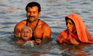 Un nen plora quan els seus pares el banyen al riu Ganges, per la celebració del Basant Panchmi a Allahabad (Índia). Milers de pelegrins hindús prenen banys sagrats amb l’esperança de rentar els seus pecats en aquest dia.