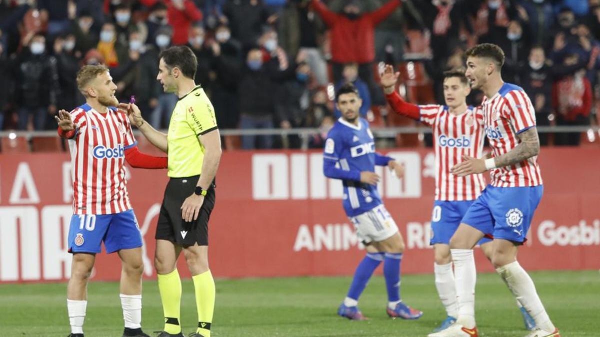 Els jugadors del Girona protesten a González Esteban. | ANIOL RESCLOSA