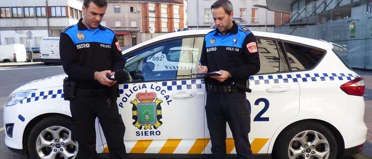 Los dos agentes de la Policía Local de Siero encargados de las mediciones, con los sonómetros, en la Pola.