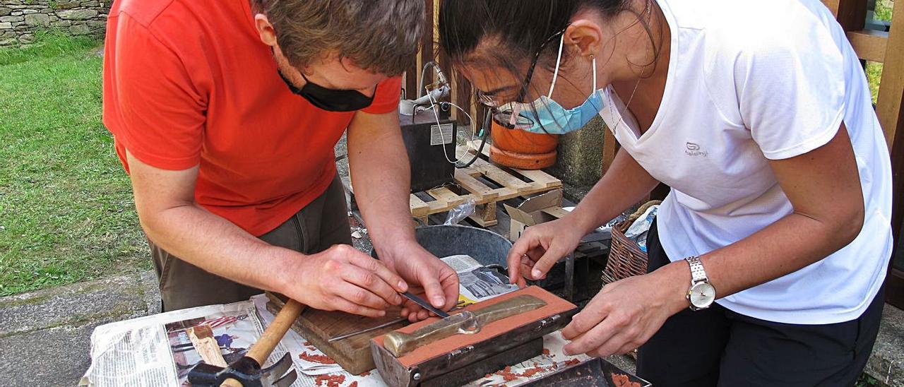 Los técnicos, con uno de los moldes empleados en la realización de las hachas.