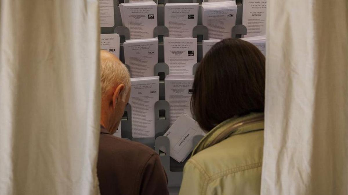 Imagen de archivo de dos personas votando durante las pasadas elecciones municipales.