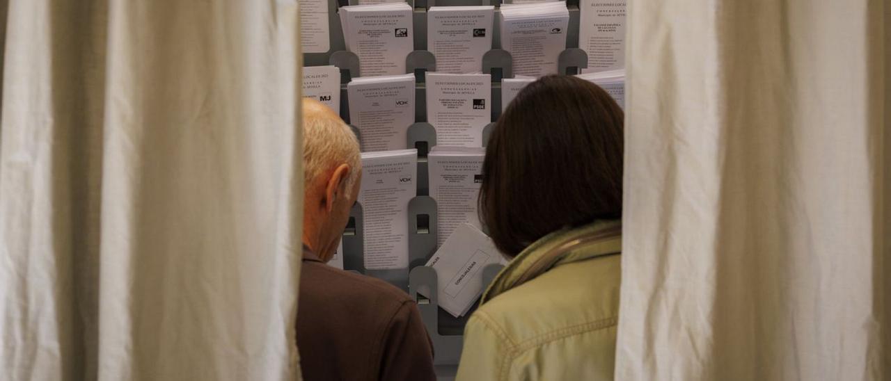 Imagen de archivo de dos personas votando durante las pasadas elecciones municipales.