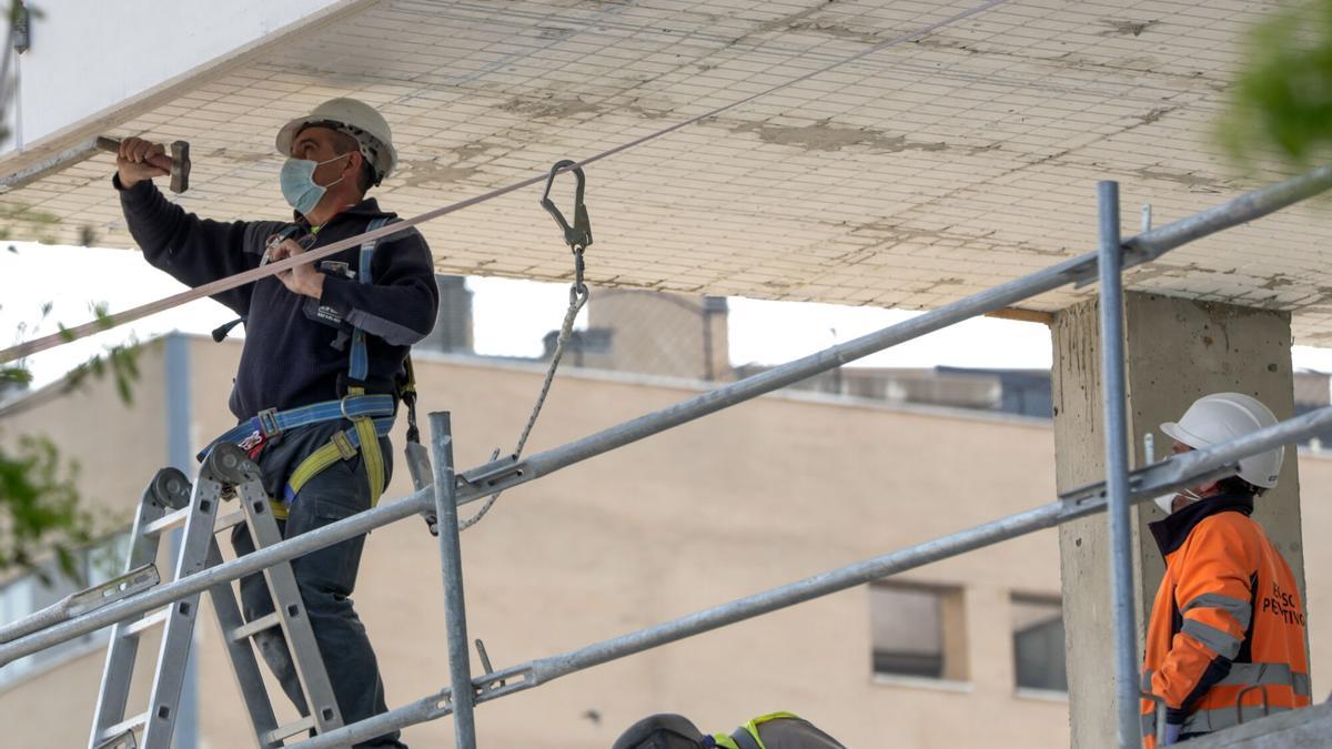 Trabajadores de una empresa de hierros trabajando en la construcción de un edificio.