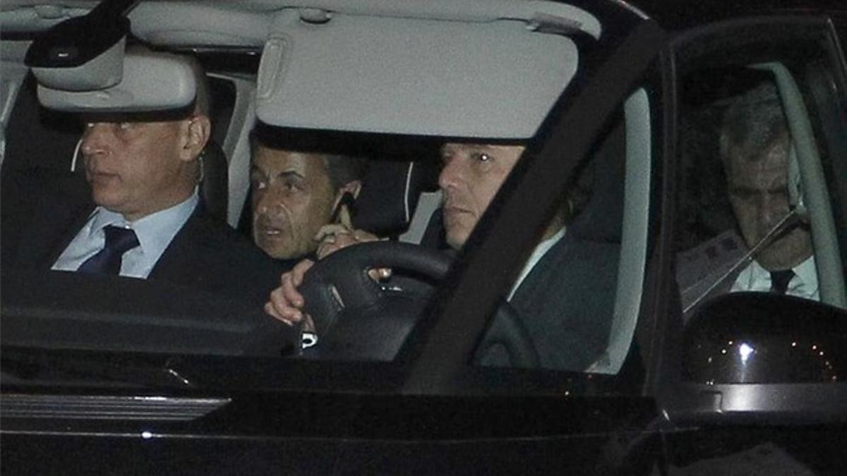 Nicolas Sarkozy habla por teléfono en su coche a la salida del tribunal.