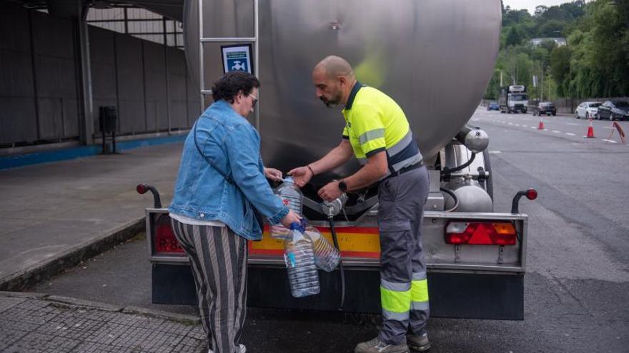 Una mujer llega garrafas con agua de una cisterna. |   // CASTELEIRO / R. AGENCIA