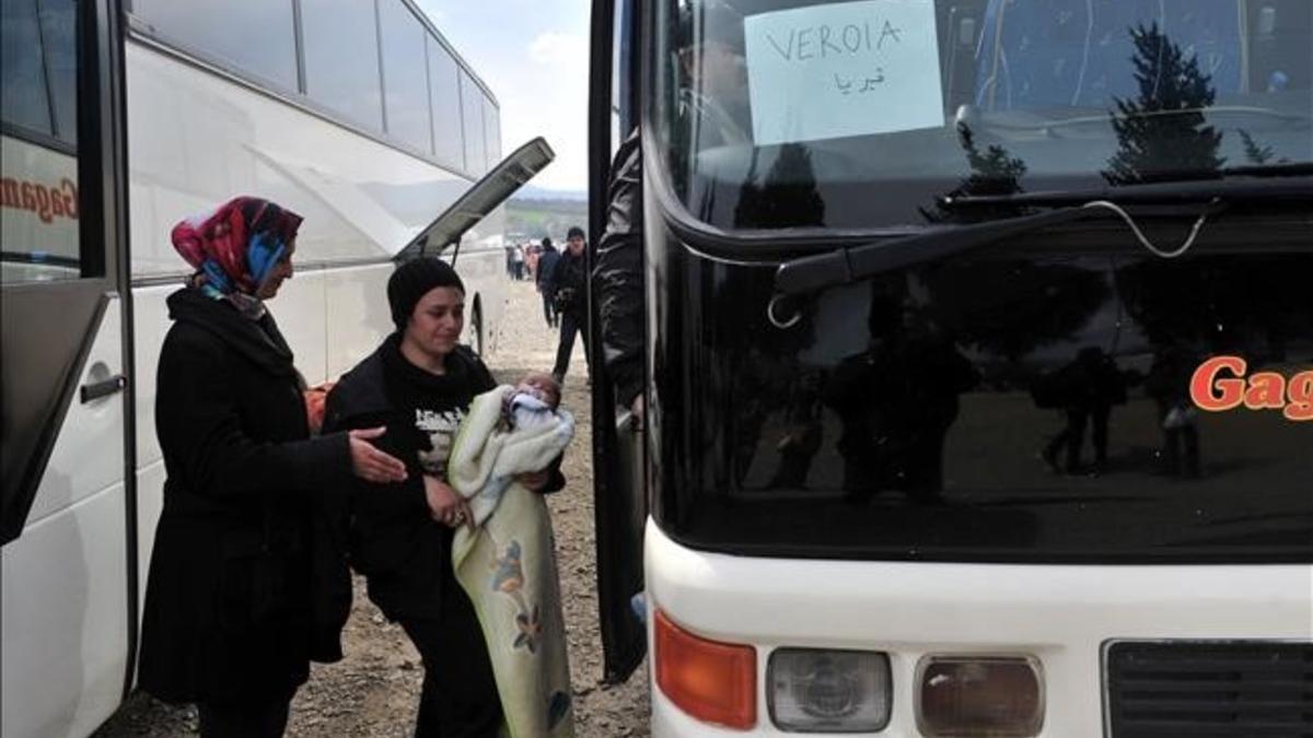 Dos mujeres se disponen a subir a un autocar en el campamento de Idomeni.