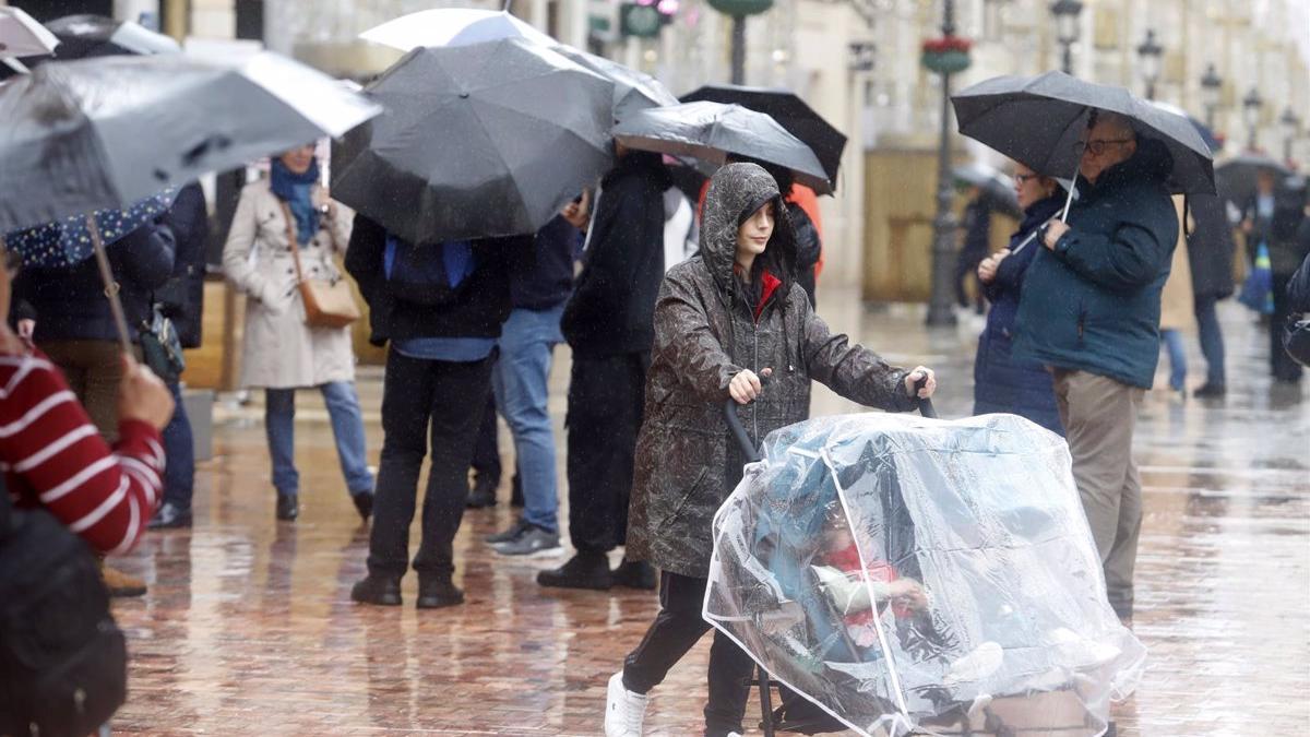Varias personas bajo la lluvia en Málaga