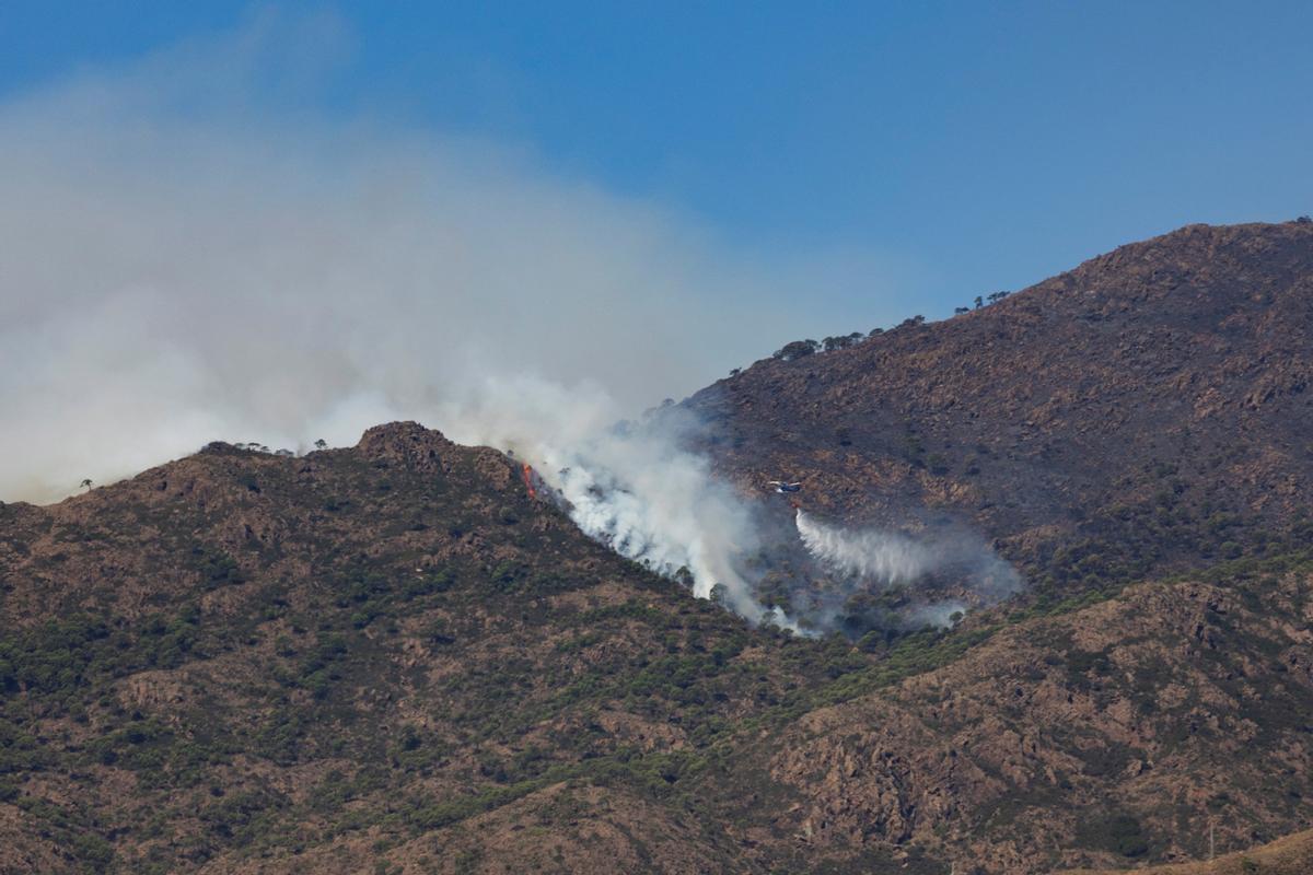 Un helicóptero realiza una descarga de agua durante la extinción del incendio de Sierra Bermeja.