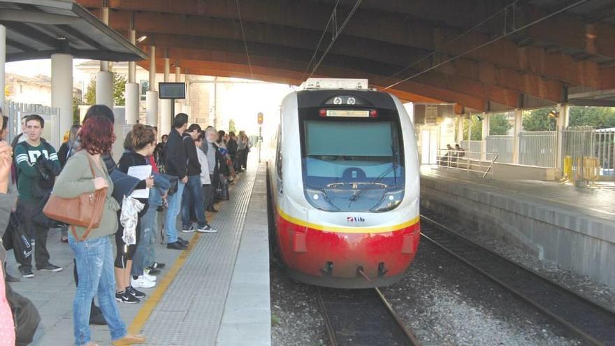 Un grupo de viajeros espera la llegada del tren en la estación de Inca.